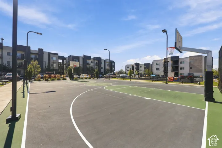 Outdoor basketball court with high-contrast surfacing, perimeter pole lighting, and backboard systems