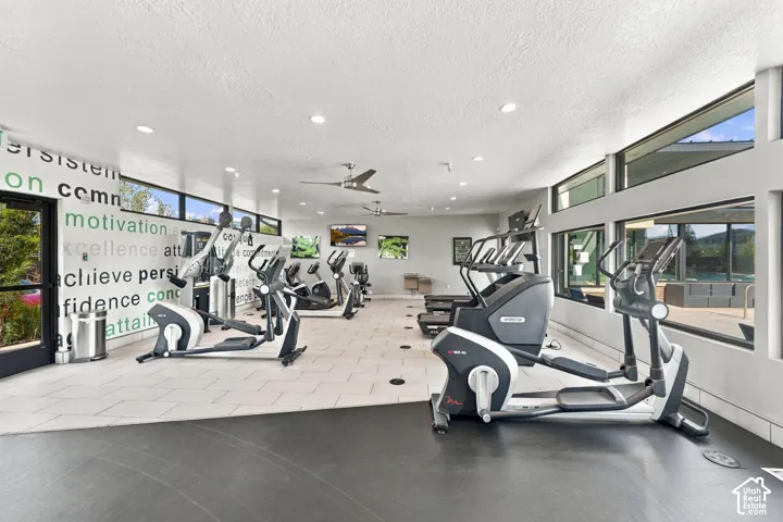 Fitness center featuring tile flooring, ceiling fans, recessed lighting, and large windows
