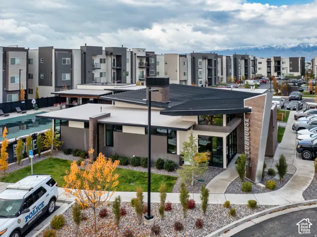 Community clubhouse featuring a modern architectural design with mixed stone and metal siding, integrated chimney, flat roofline, and onsite swimming pool