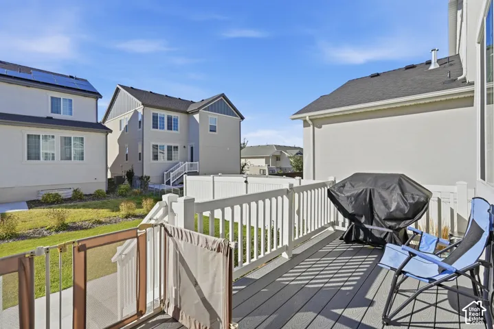 Raised deck featuring composite decking, white vinyl railing, and staircase access to a fenced rear yard