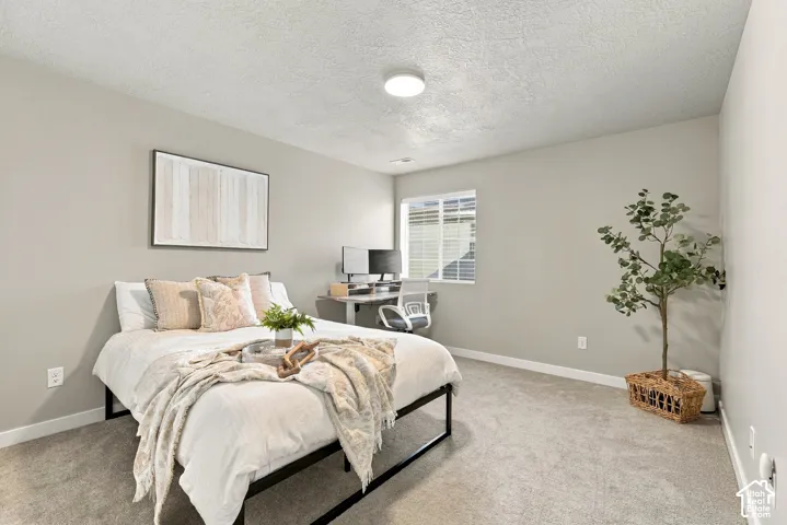 Neutral-toned interior space featuring light-colored wall paint, plush carpeting, and a dual-pane sliding window with integrated overhead lighting