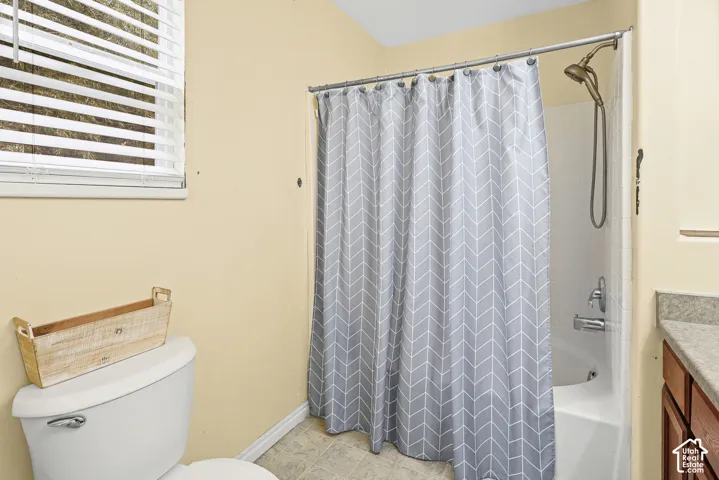 Shower-tub combination featuring a white surround, a curved curtain rod, and a multi-setting hand-held showerhead