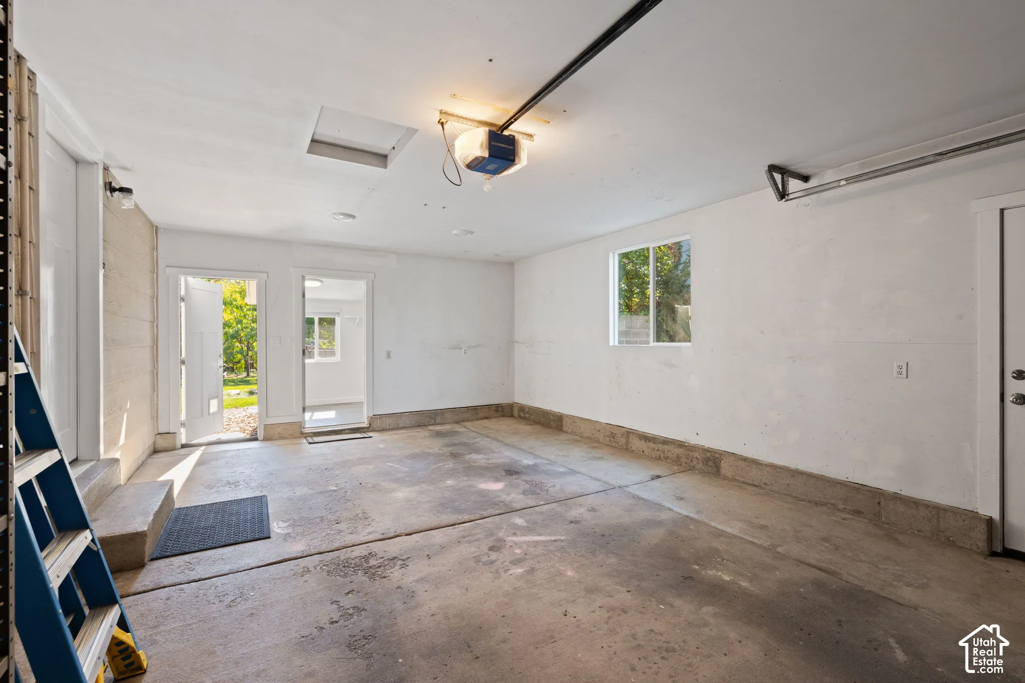 Garage interior featuring a concrete floor, painted masonry walls, and multiple points of entry