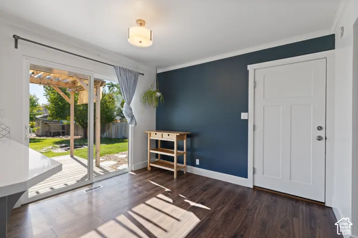 Sliding glass doors providing exterior access, wood-finish flooring, accent wall, and a flush-mount ceiling light fixture