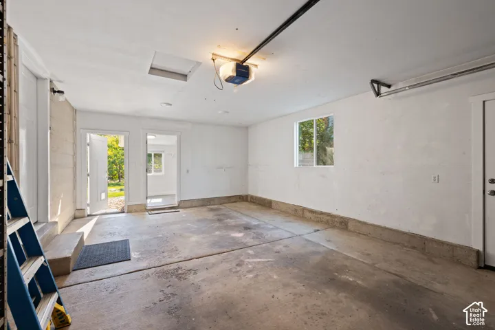 Garage interior featuring a concrete floor, painted masonry walls, and multiple points of entry