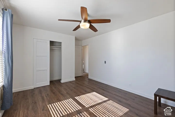 Interior space featuring wood-finish flooring, a ceiling fan with integrated lighting, and a closet with sliding panel doors