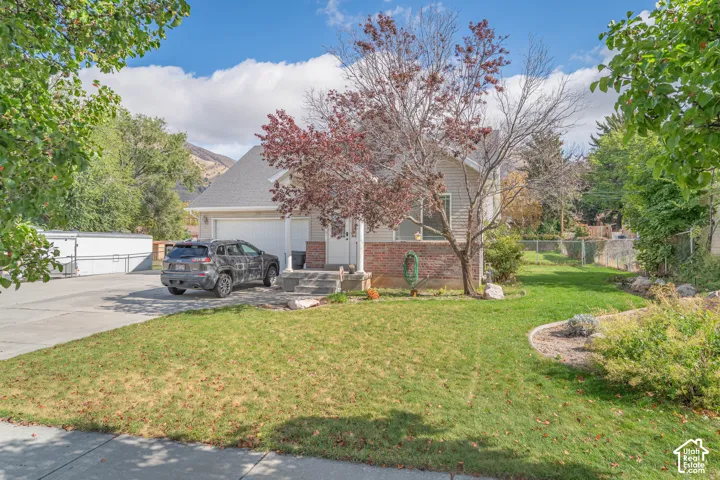 Single-story residence featuring a brick and horizontal siding facade, two-car garage, covered entryway, and landscaped front lawn with mountain backdrop