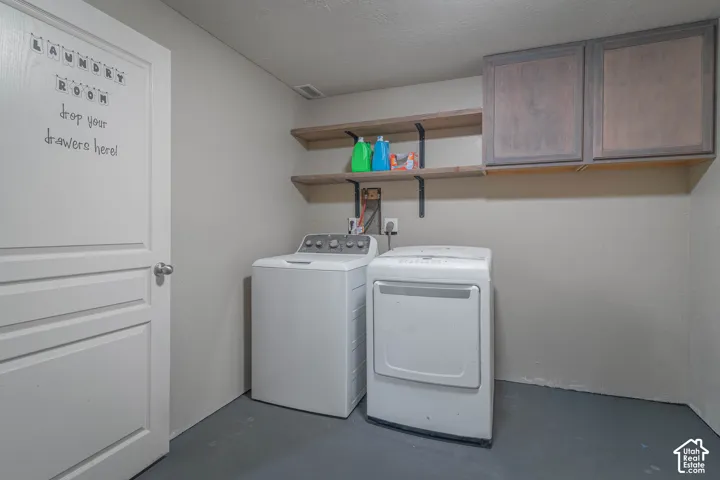 Utility space featuring upper cabinetry, tiered open wood shelving, and a paneled interior door