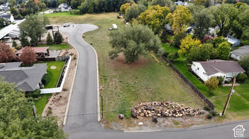 Expansive parcel featuring paved cul-de-sac access, mature trees, and natural stone hardscaping