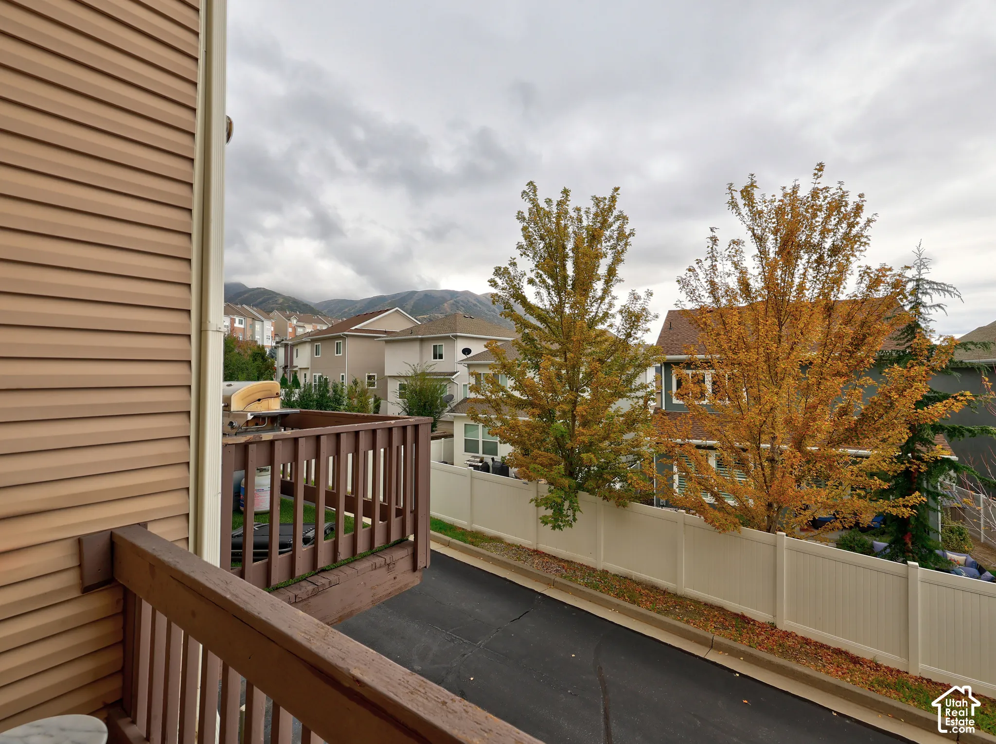 Elevated wooden balcony featuring horizontal siding exterior and mountain scenery