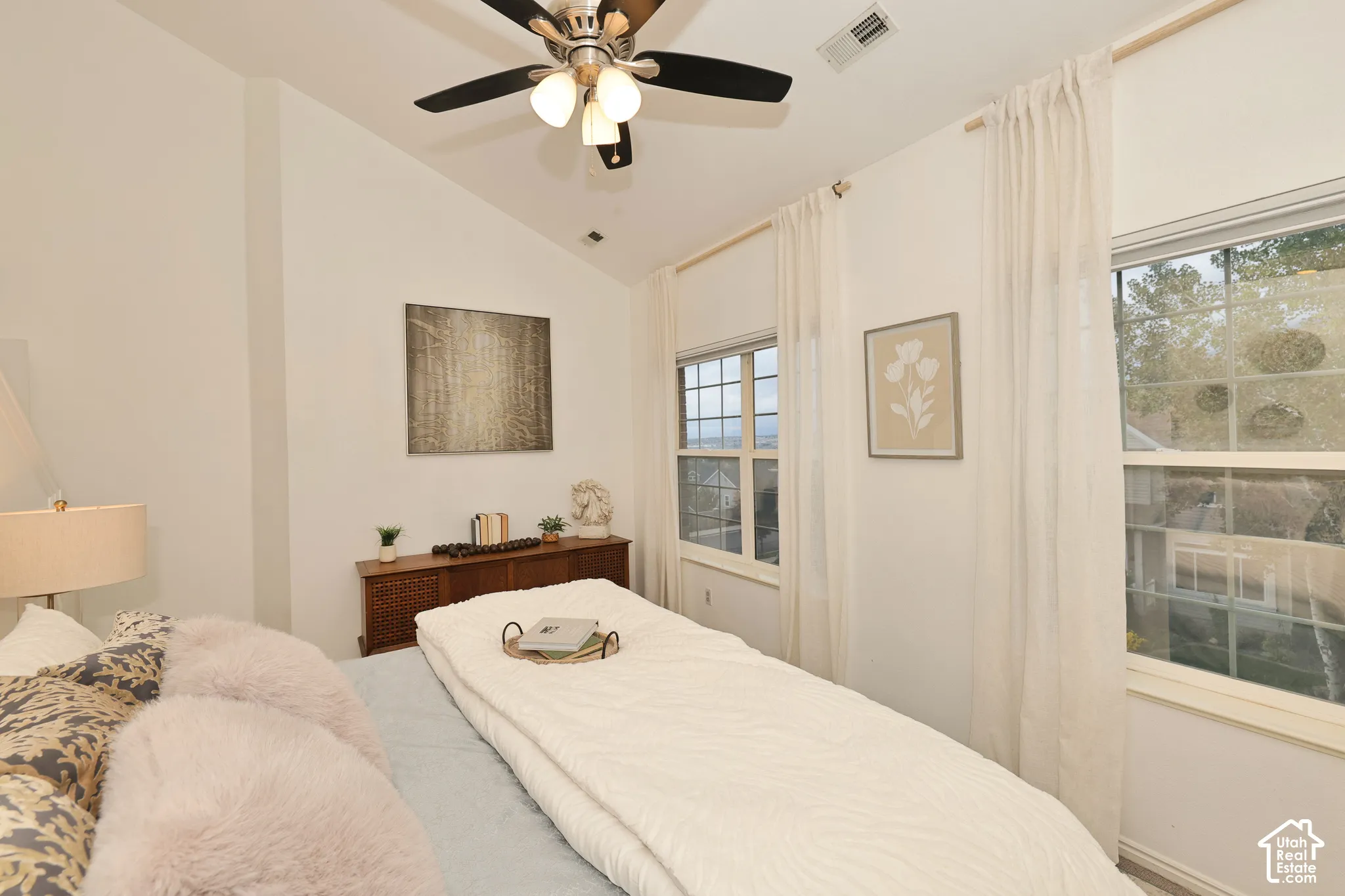 Vaulted ceilings, multi-light windows, and a ceiling fan with integrated lighting