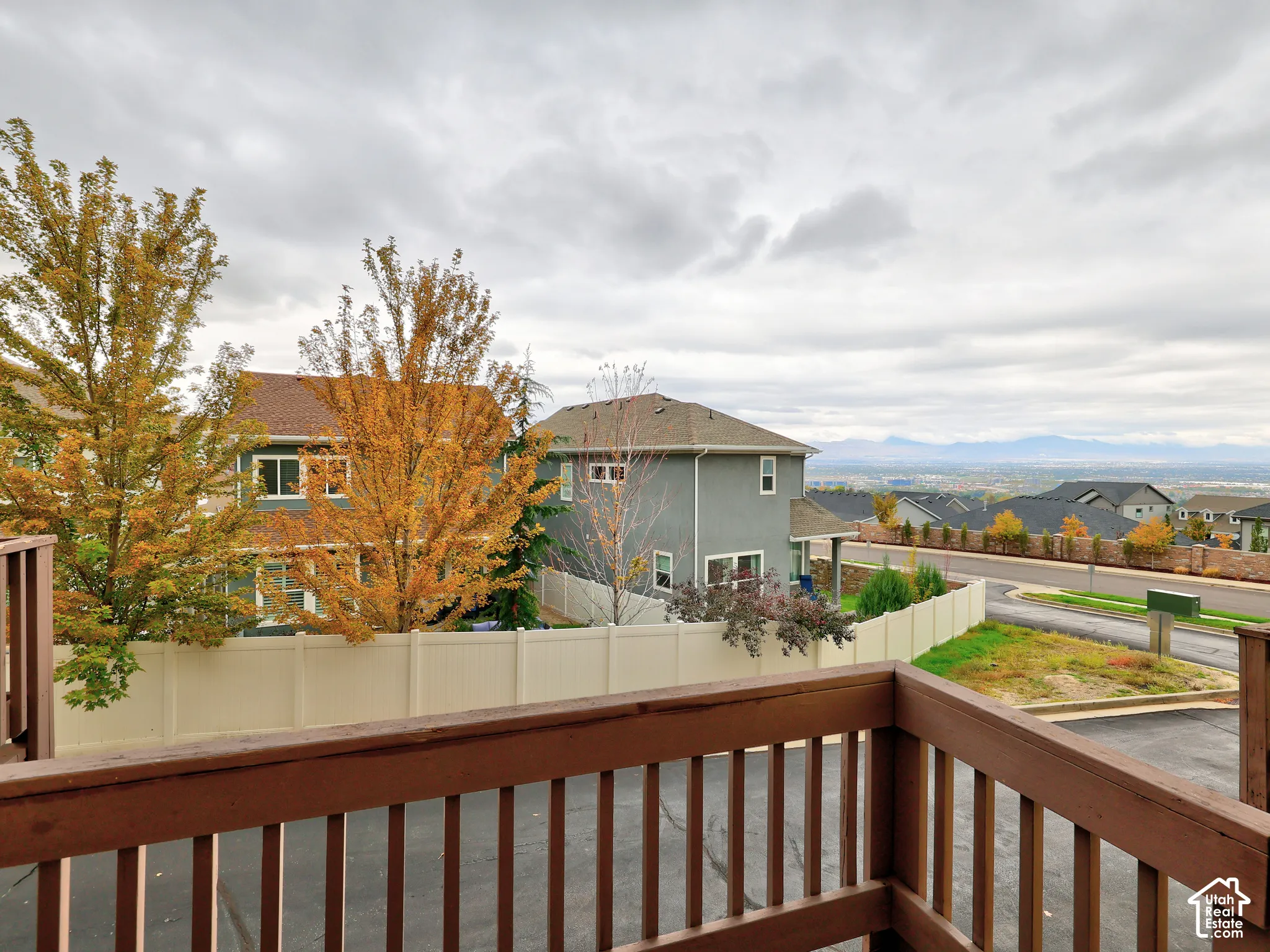 Elevated deck with wooden railings, featuring an expansive horizon backdrop and mountain silhouettes