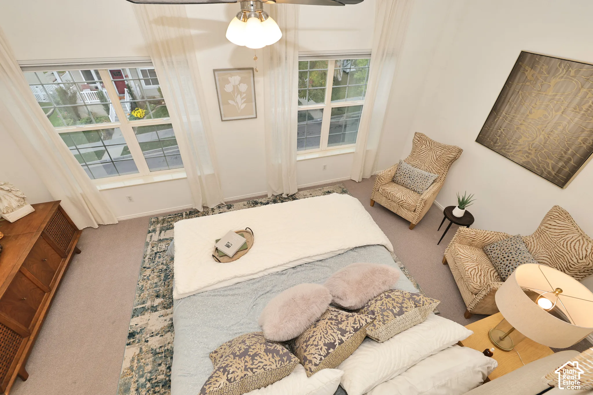 High-ceiling space featuring dual-pane windows, wall-to-wall carpeting, and a ceiling fan with integrated lighting