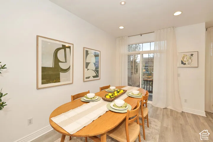 Recessed lighting, light-toned wood-finish flooring, and a sliding glass door with a transom window