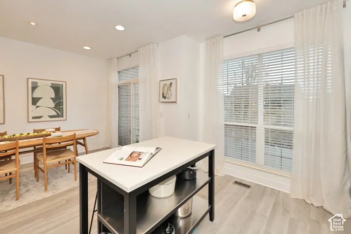 Wood-finish flooring, recessed lighting, and large windows with horizontal blinds
