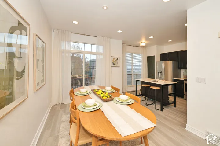 Kitchen featuring a center island, recessed lighting, wood-finish flooring, dark-toned cabinetry, and a glass sliding door
