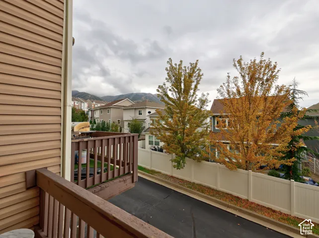 Elevated wooden balcony featuring horizontal siding exterior and mountain scenery