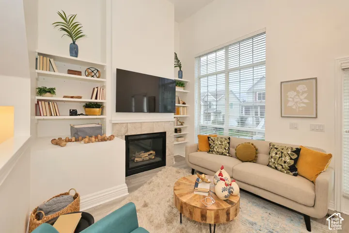 Floor-to-ceiling windows, fireplace with tiled surround, and built-in floor-to-ceiling shelving
