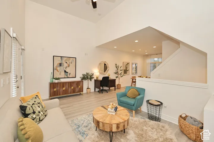 Vaulted ceilings, wood-finish flooring, recessed lighting, and a neutral wall palette