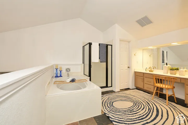 Built-in soaking tub, walk-in shower with black-frame enclosure, vanity with integrated cabinetry, and full-width vanity mirror