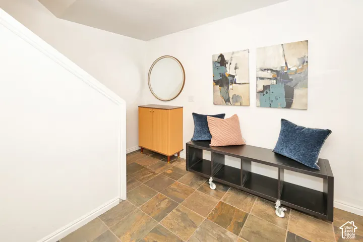 Neutral-toned wall finish with multi-colored stone-tile flooring