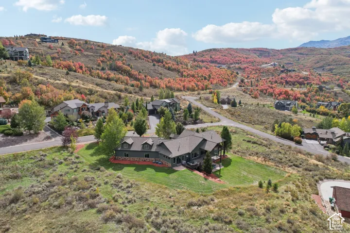Expansive property featuring a green lawn, mature trees, and a multi-level deck