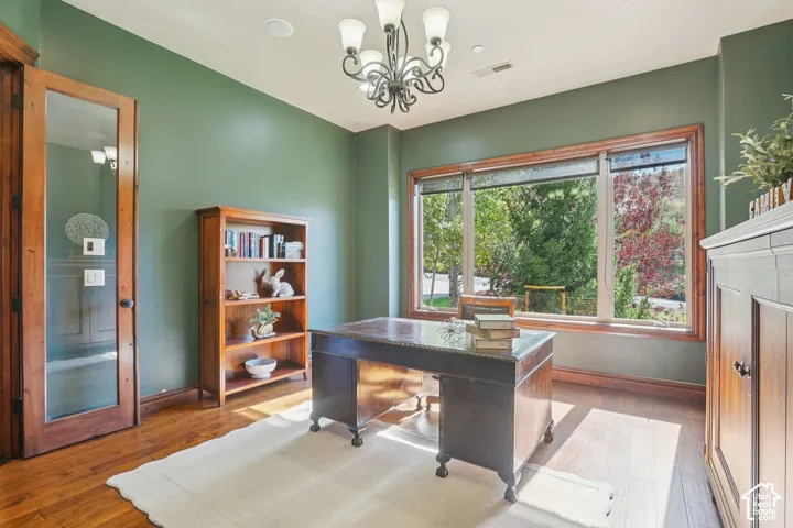 Hardwood flooring, wood-framed window, built-in recessed lighting, decorative chandelier, wood-framed door with glass panel