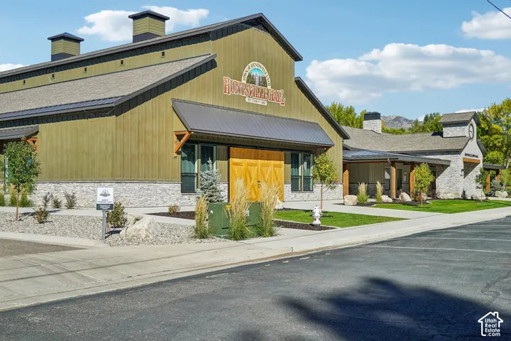 Barn-style structure with vertical siding and stone wainscoting