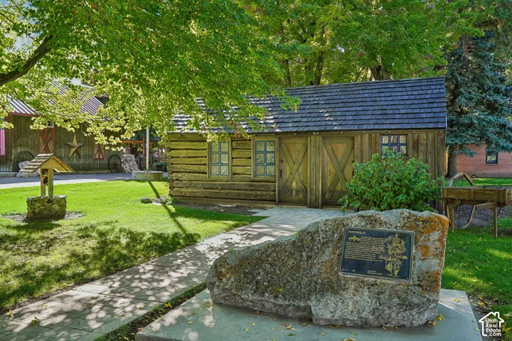 Wood-sided structure with a shingled roof and decorative windows