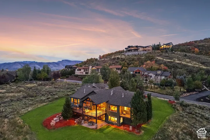 Two-story residence with multiple outdoor deck spaces, extensive window placement, and surrounding mature landscaping