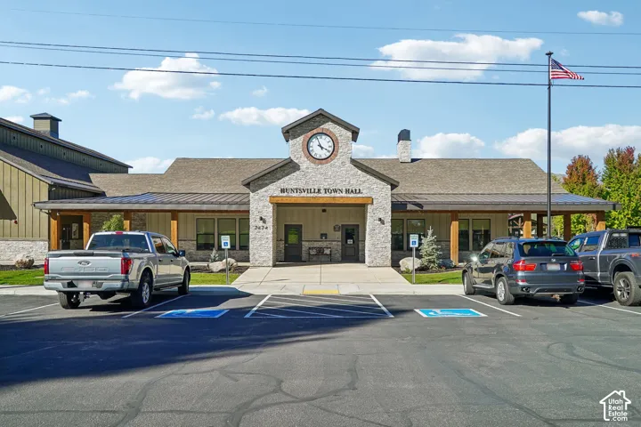 Stone-clad town hall with an integrated clock tower, covered entry porch, and adjacent parking area