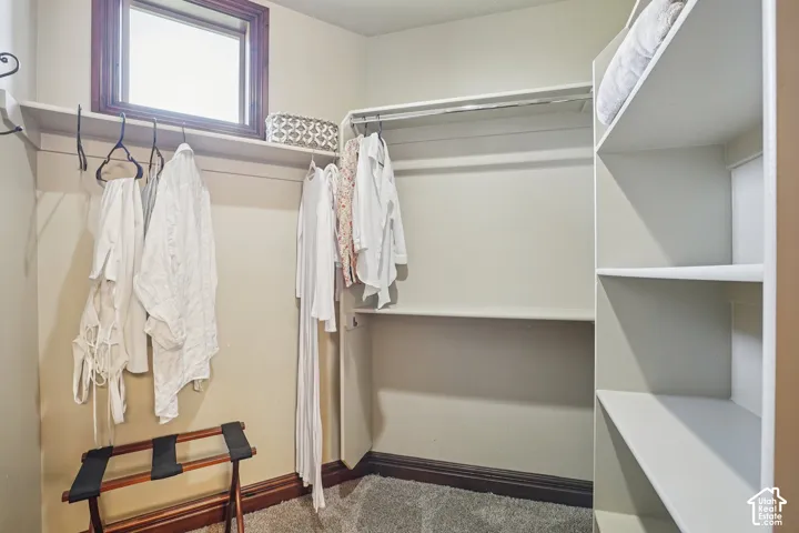 Built-in shelving and hanging rods for organized storage, complete with a window and wood-trim accents