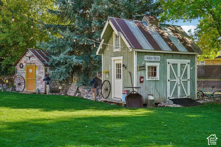 Expansive green lawn with two detached sheds featuring corrugated metal roofs