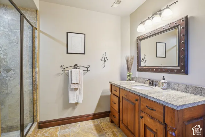 Wood-finish vanity with dual integrated sinks, stone countertop, and an ornate framed mirror