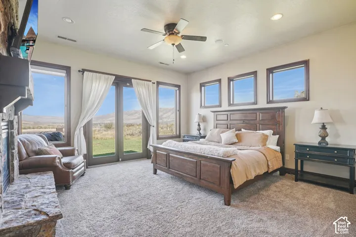 Expansive room featuring a stone fireplace, recessed lighting, and a ceiling fan