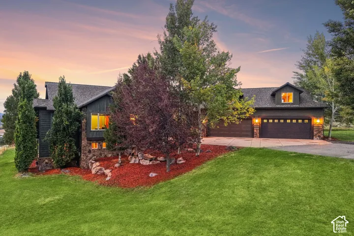 Multi-level exterior with dark siding, stone accents, and a shingle roof