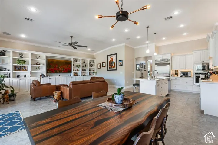 Open-concept interior featuring built-in cabinetry, recessed lighting, a kitchen island with stone countertops, and tile flooring
