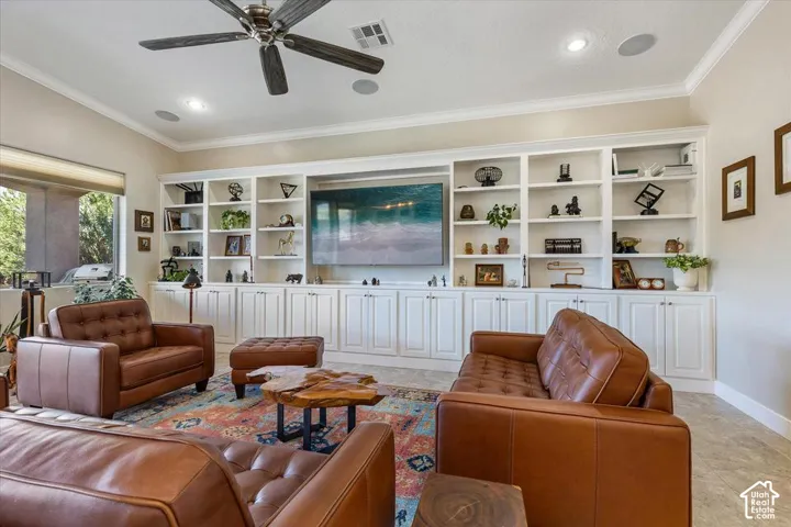 Built-in floor-to-ceiling white cabinetry with integrated shelving, crown molding, tile flooring, and a ceiling fan