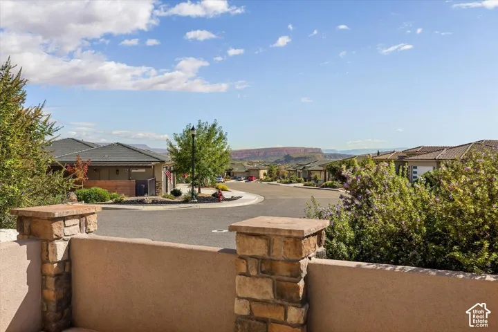 Terrace featuring stucco walls, stone-capped pillars, and a horizon showcasing geological formations
