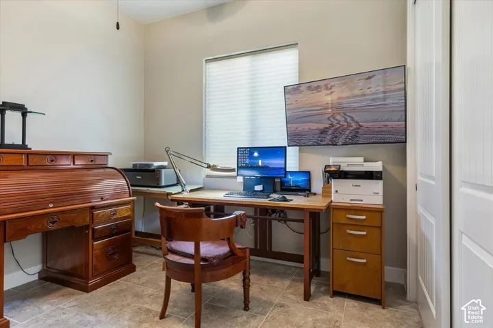 Neutral-toned room with stone-finish tile flooring, a window featuring horizontal blinds, and a paneled closet door