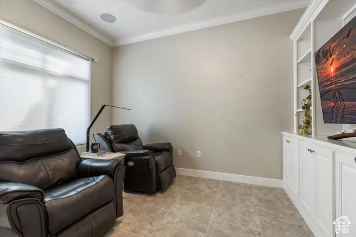 Built-in floor-to-ceiling cabinetry, tile flooring, crown molding, and recessed ceiling speakers