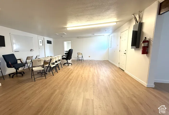 Spacious interior featuring wood-finish flooring, recessed lighting, and white walls
