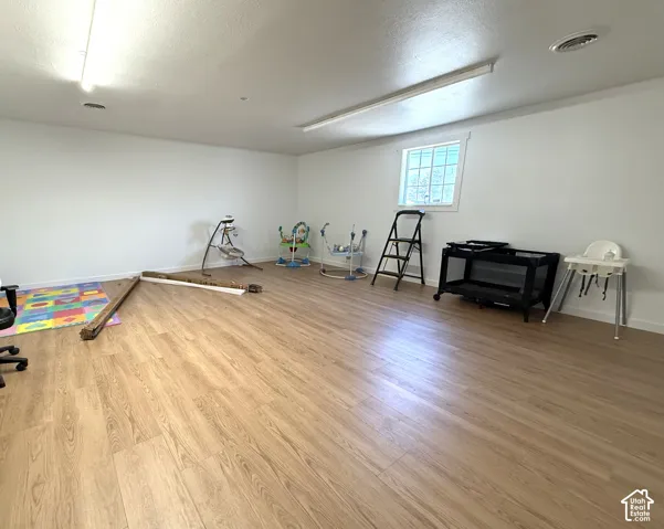 Open interior space featuring wood-finish flooring, neutral wall paint, and recessed lighting fixtures