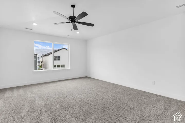 Primary bedroom with vaulted ceiling and ceiling fan.