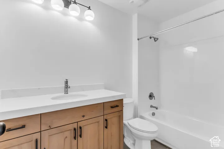 Full secondary bath with stained wood cabinets and quartz slab countertops.