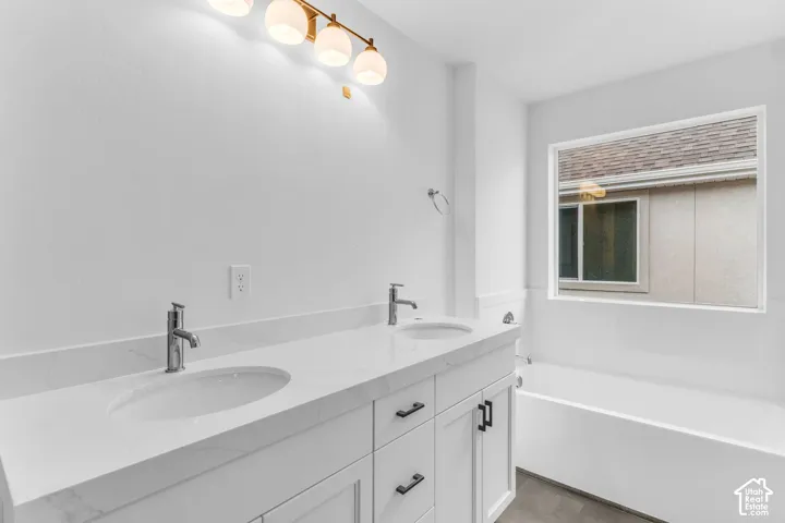 Dual sinks, painted white wood cabinets, quartz countertops and soaker tub.