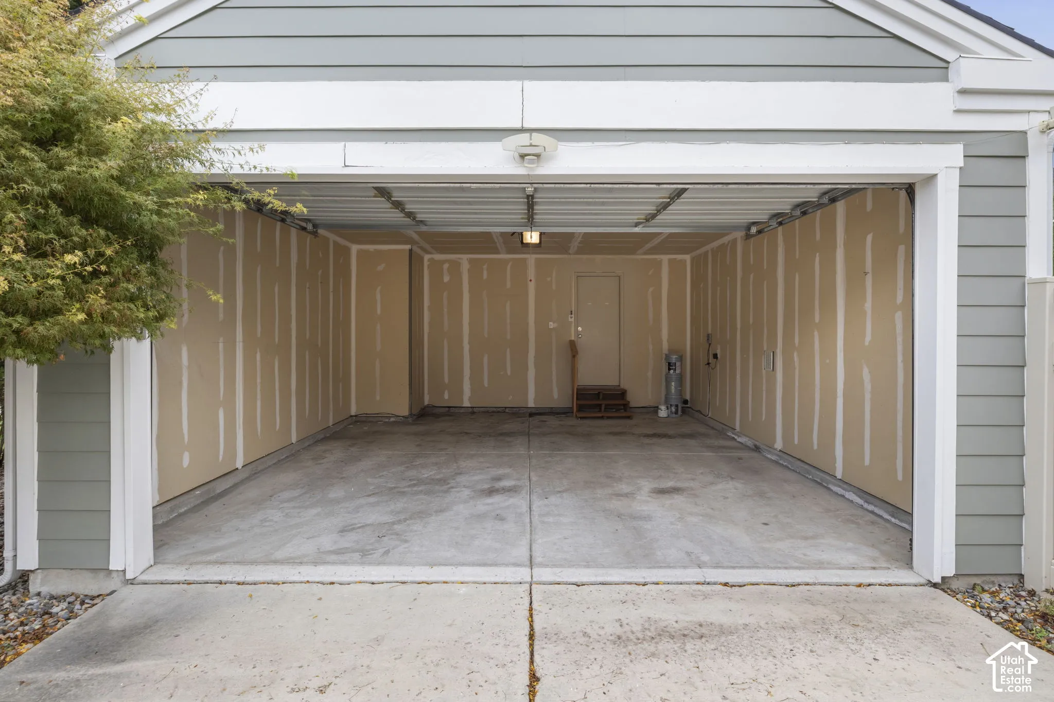 Two-car garage featuring a concrete floor, lap siding exterior, and an interior access door