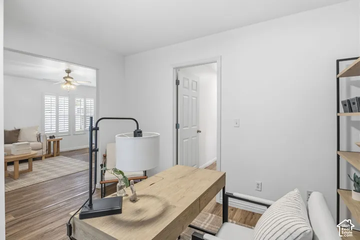 Wood-finish flooring, white walls, and white interior doors with satin nickel hardware