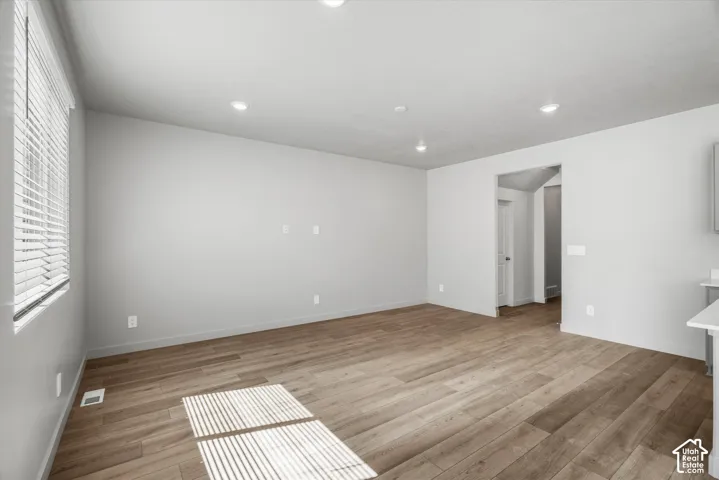 Interior space featuring wood-finish flooring, recessed lighting, and horizontal window blinds