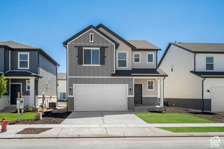 Two-story exterior featuring a mix of vertical board-and-batten and horizontal siding, a covered front entryway, attached two-car garage, decorative exterior shutters, and concrete driveway